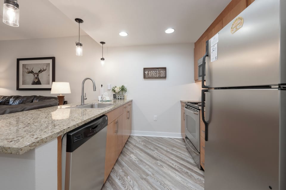 Your modern kitchen features granite counters, stainless appliances, and warm wood cabinets—perfect for cooking mountain meals together.