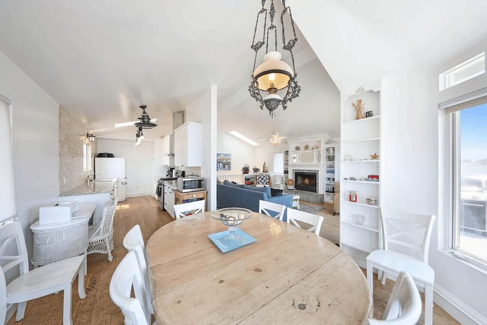 View from the upstairs dining area looking back into the kitchen and living room. Beyond the living room is the hallway which leads to bedrooms/bathrooms.
                