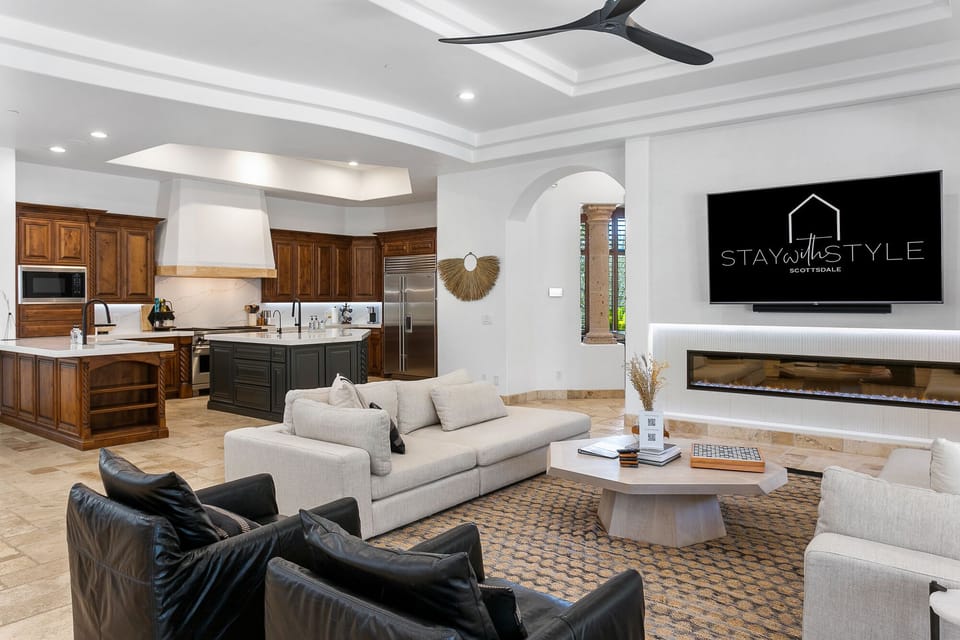 Sit down and relax with this cozy fireplace, large TV, kitchen, solar shades for privacy