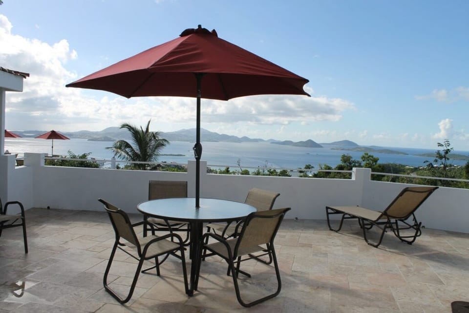 Patio Paradise: Enjoy panoramic sea views under the shade of a vibrant umbrella!