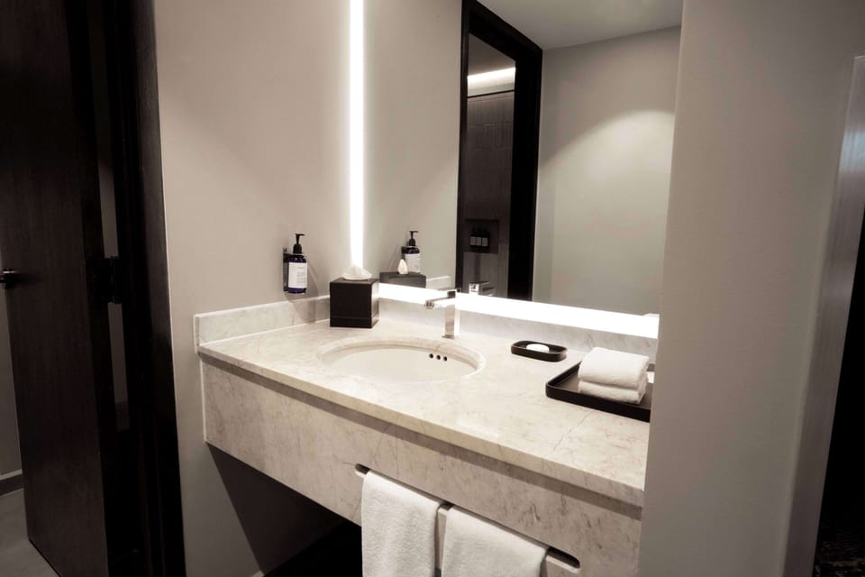 Bathtub, designer toiletries, hair dryer, towels