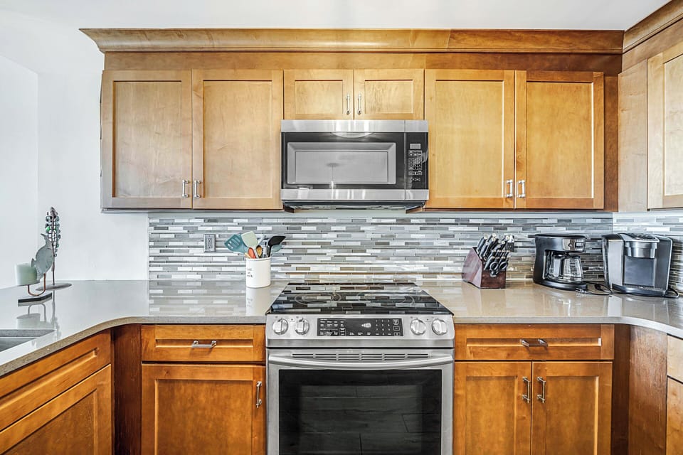 The fully equipped kitchen features quartz countertops, stainless-steel appliances, and has everything you need to prepare meals for family & friends.