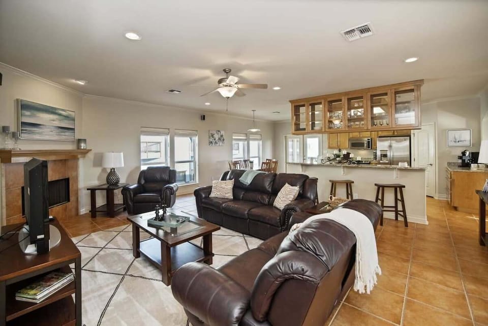 Open Living Room with Leather Sofas, Fireplace & Kitchen Bar