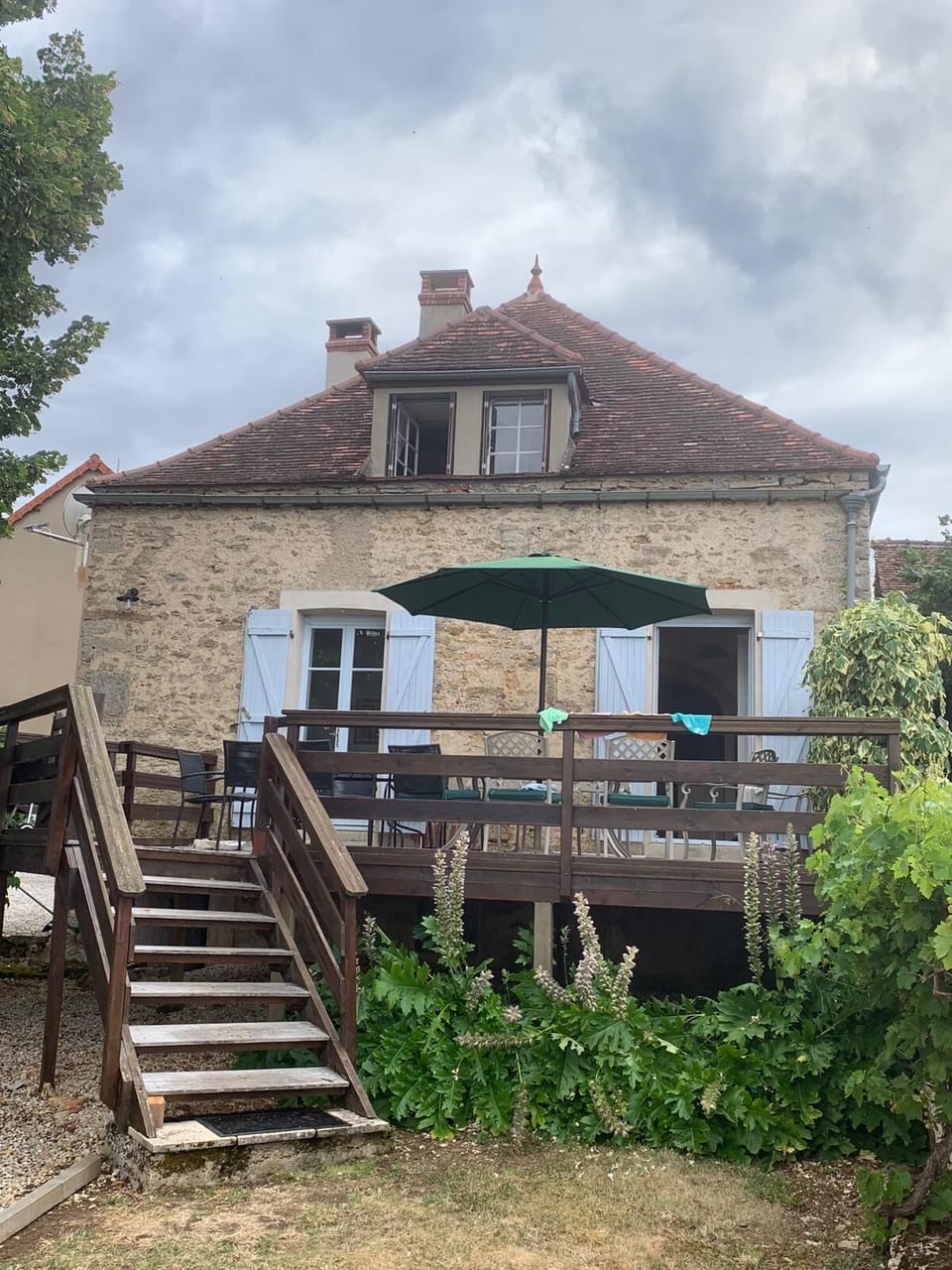 There is a large terrace with two tables, a BBQ and a sunshade

