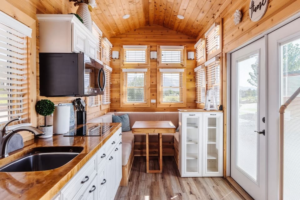 The kitchen is fully equipped with a refrigerator, freezer, microwave, cooktop, and sink with hot/cold water. Enjoy coffee from the coffee maker and ample counter space. Essentials include cookware, dishes, utensils, and plenty of storage cabinets.