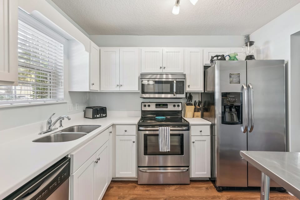 Bright, well-equipped kitchen with stainless appliances, crisp white cabinetry, and plenty of counter space for preparing your favorite meals during your stay.