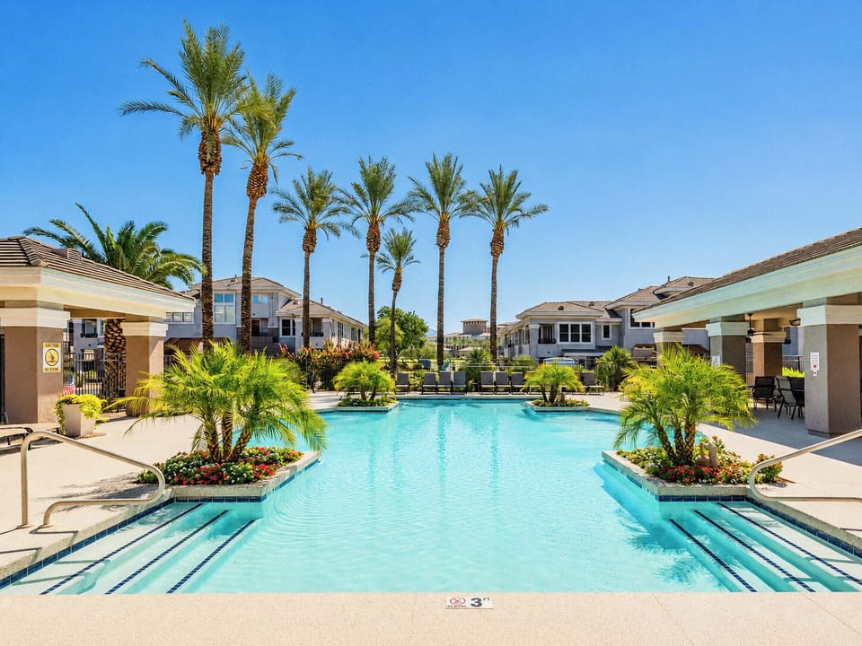 Resort-style heated pool surrounded by palms and the clear blue sky's of Arizona