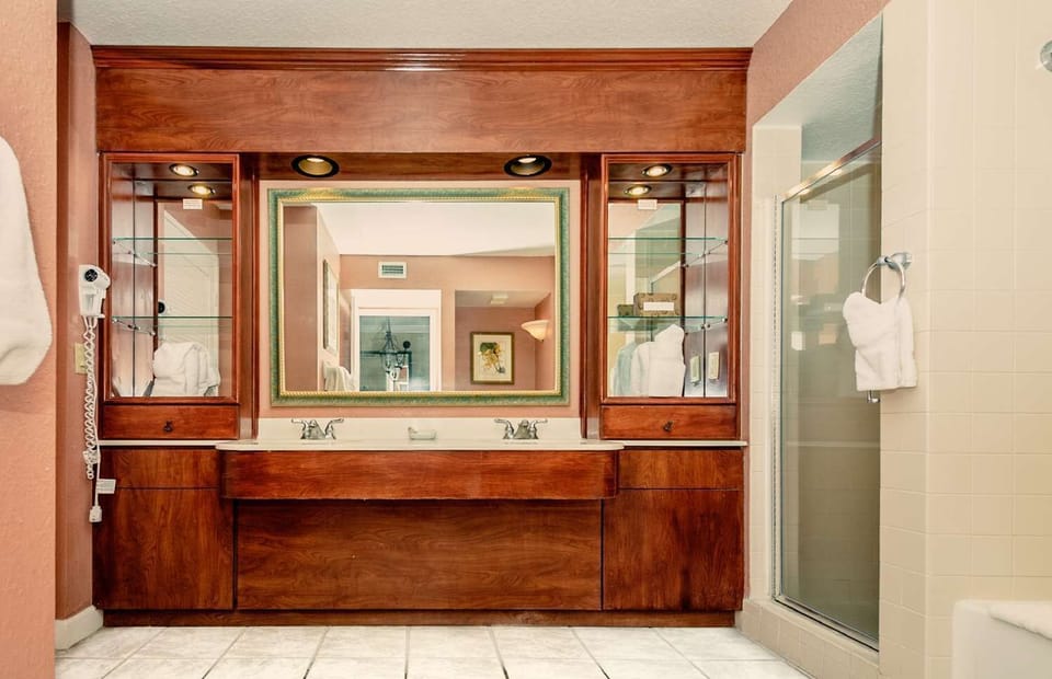 Full bathroom features dual vanities, shower, and a bath tub.