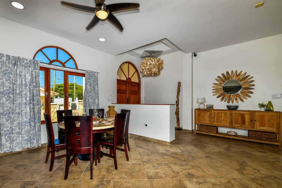Marvelous dining area of the 3BR House in Noord Aruba - Beautiful window facing dining area of the house - Elite 6 persons dining - Stunningly located large windows with mesmerizing views - Majestic decored space with beautiful paintings