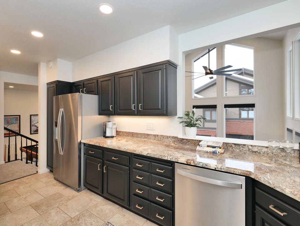 Fully stocked kitchen with lookout into living room.
 