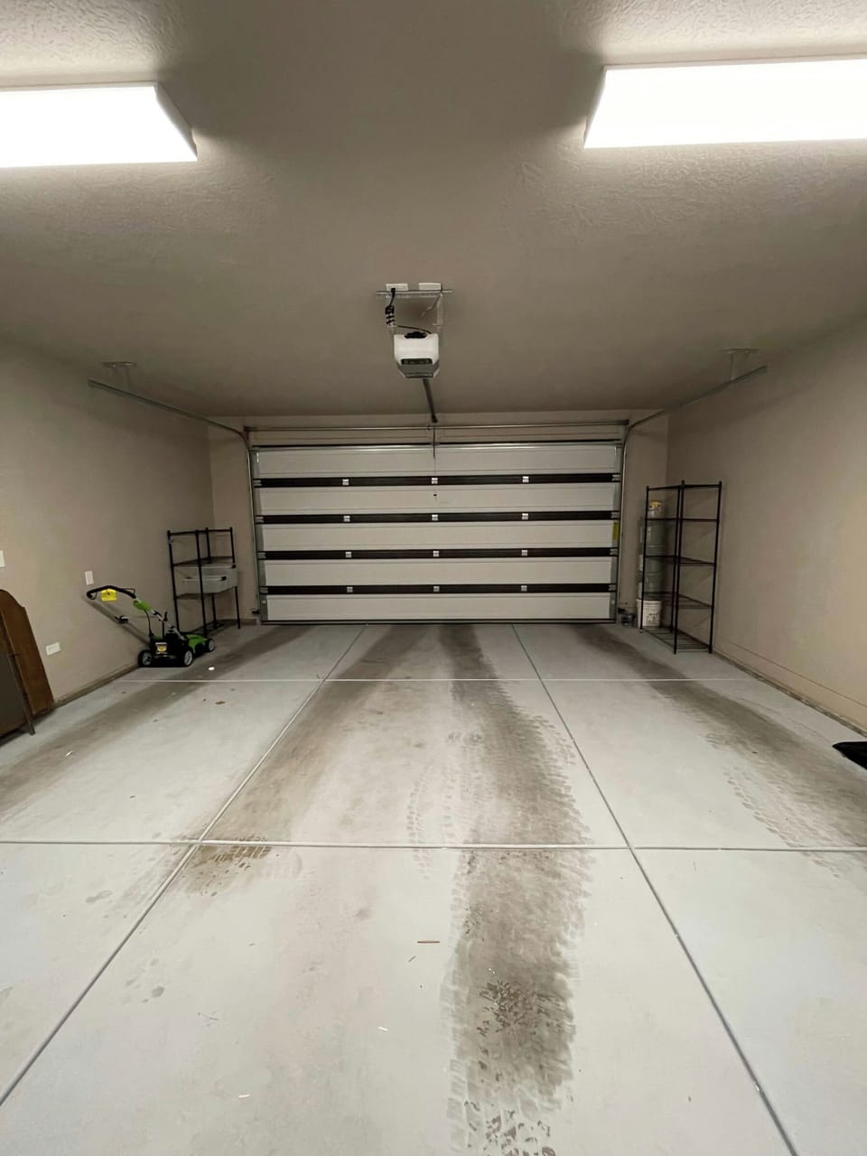 Spacious attached garage with automatic door opener and shelving for extra storage at Maison Sans Souci.