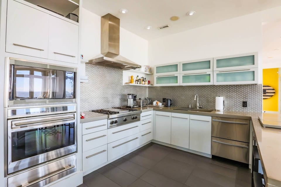 The modern kitchen features a Fisher & Paykel dishwasher, Wolf oven & cooktop and Sub Zero refrigerator.