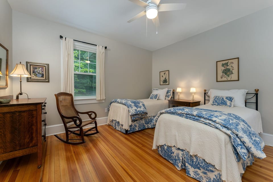 Main level bedroom with 2 Twin beds, in-room sink, and porch access.
