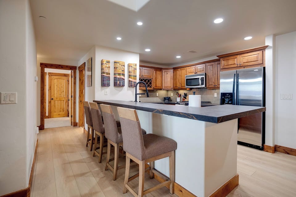 Your gourmet kitchen features rich wood cabinetry, granite countertops, and a breakfast bar where you can enjoy morning coffee together.