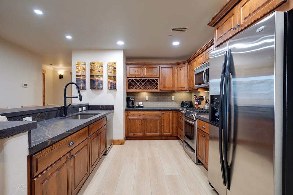 Your gourmet kitchen awaits with rich wood cabinetry, granite counters, and stainless steel appliances ready for memorable meals.