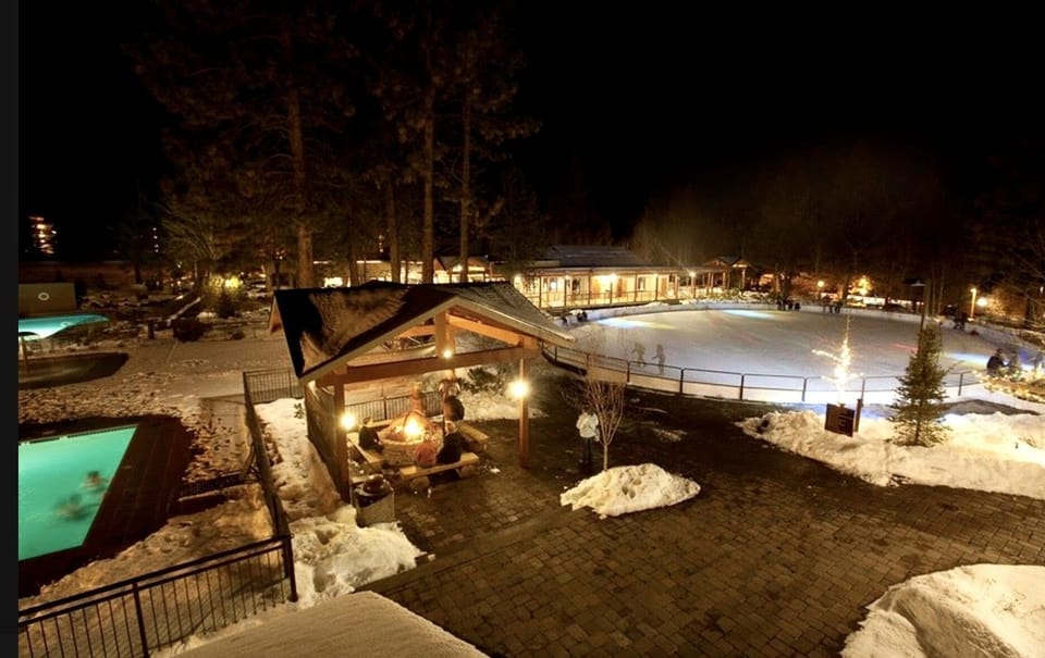 Nighttime view of the winter ice skating rink and pool.