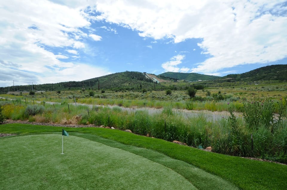 Scenic putting green with mountain views and natural surroundings—perfect for practicing your short game in a peaceful outdoor setting.