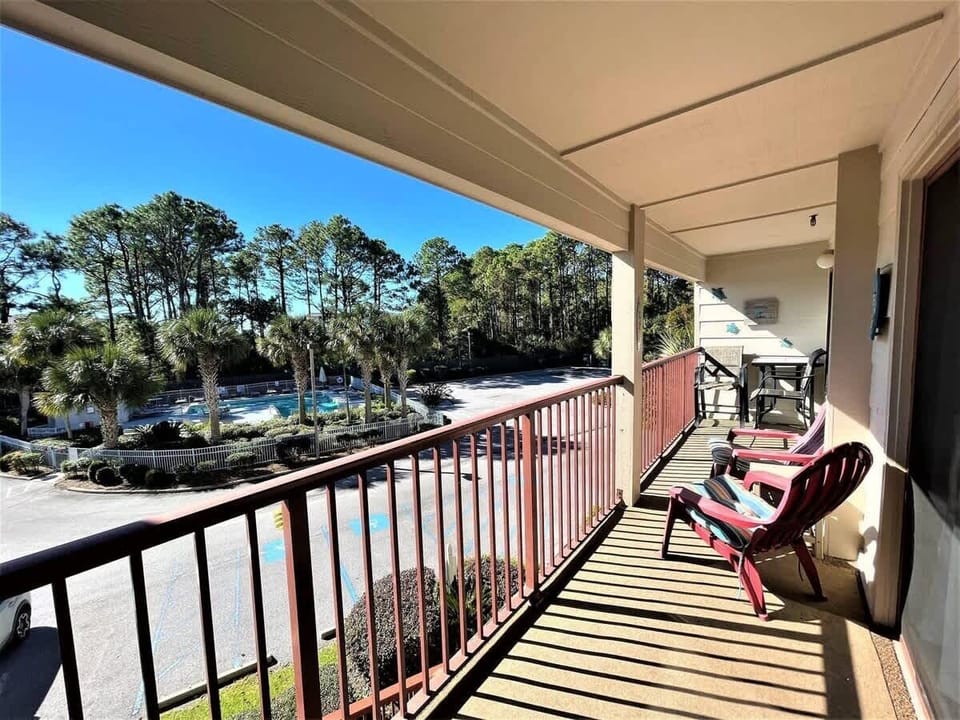 A spacious covered balcony with seating, offering a peaceful view.