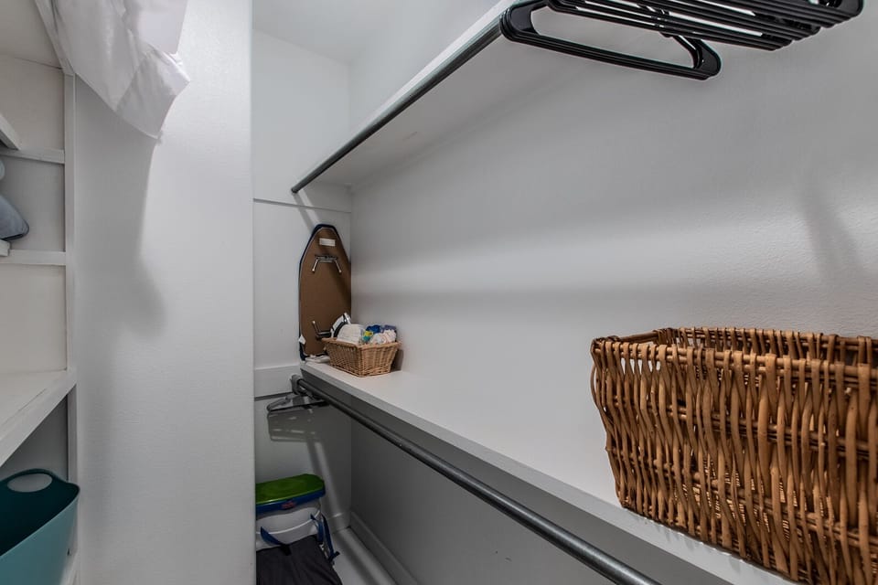 Closet with extra blanket and pillows, pack n play, ironing board, hangers, high chair