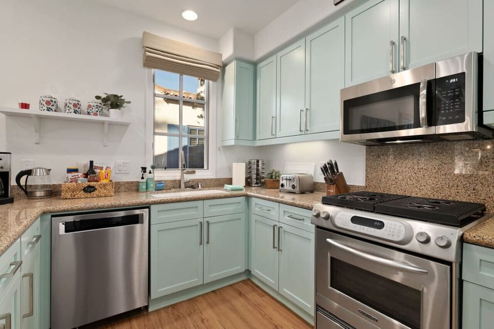 The kitchen was updated and reimagined with luxury vinyl plank flooring, colorful shaker cabinetry, granite counter tops, Kitchenaid dishwasher and gas range + GE Microwave.