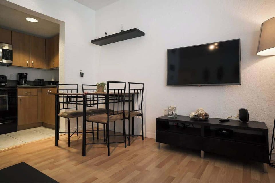 Enjoy meals and movie nights in this cozy Airbnb with open kitchen, dining space, and entertainment setup.

