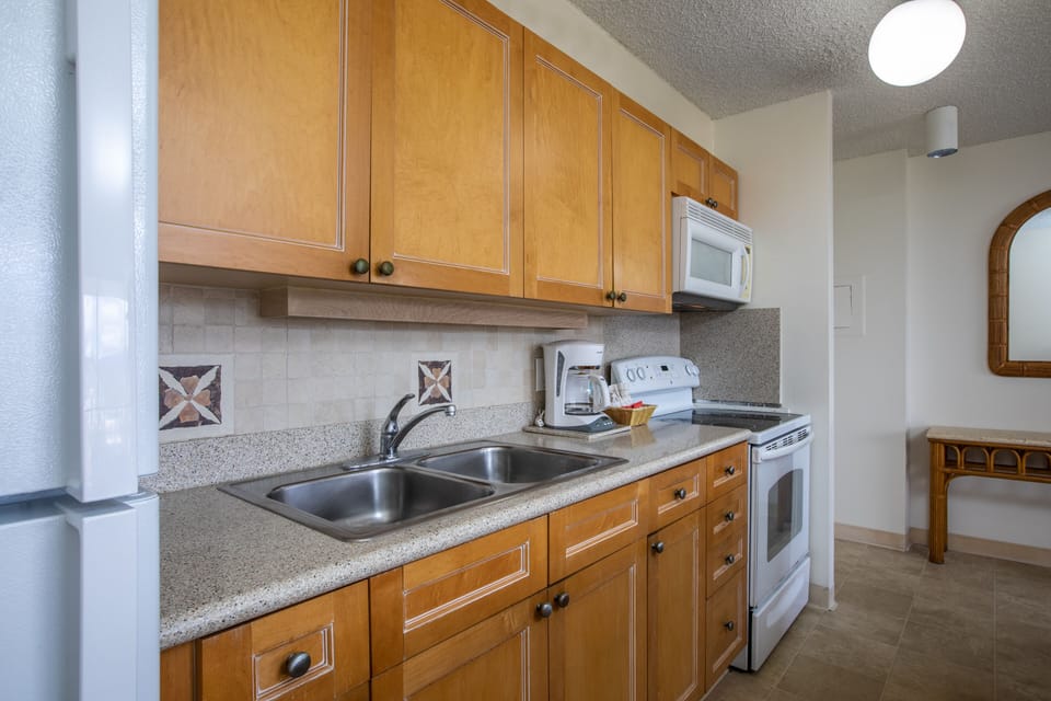 Your well-equipped kitchen features granite countertops, stainless steel double sinks, modern appliances, and warm wood cabinetry—everything needed to prepare meals just the way you like them.