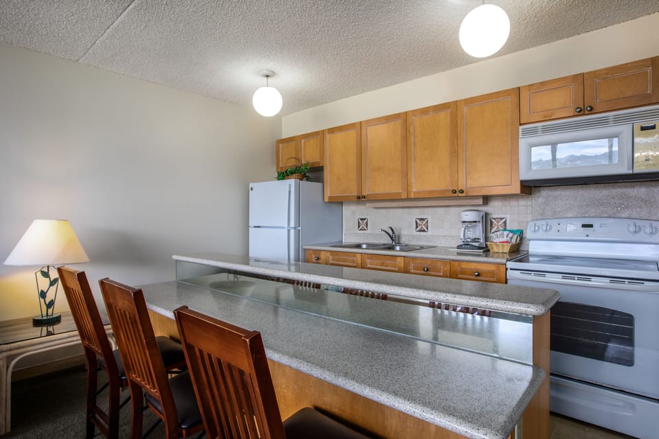 Prepare your favorite meals in this well-equipped kitchen with spacious countertops, full appliances, and a breakfast bar where you can gather for casual dining and morning coffee.