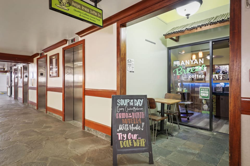 A hallway leads to an on-site coffee shop where you can grab fresh coffee and the soup of the day, with elevator access nearby.