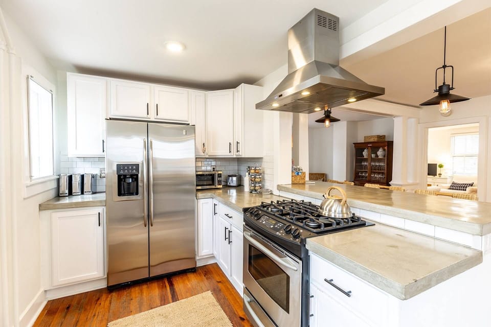 The updated kitchen's stainless-steel appliances are complete with a gas range, and hood.
