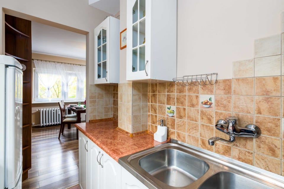 The kitchen equipped with a gas hob, fridge, oven and all necessary kitchen utensils and cookware for preparing and serving meals.