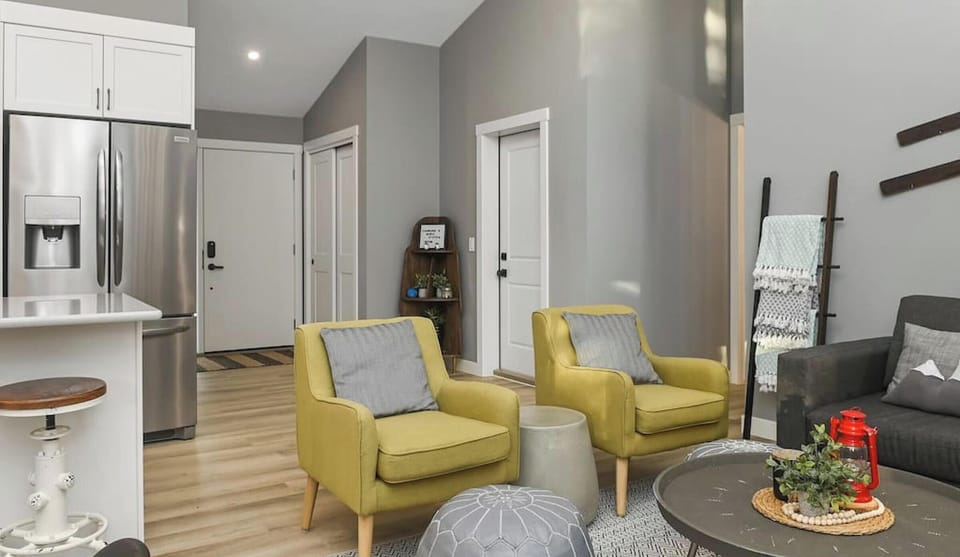 Main floor living room with cozy seating options and walkout access to the private deck space.