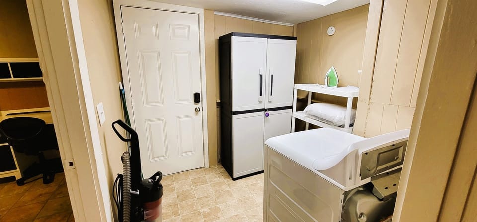 full size washer and dryer in the unit, with iron and ironing board