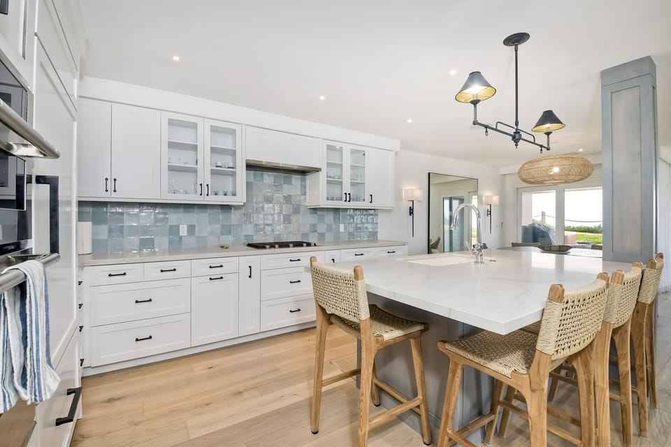 Inviting, airy kitchen featuring large island and seating for 4.