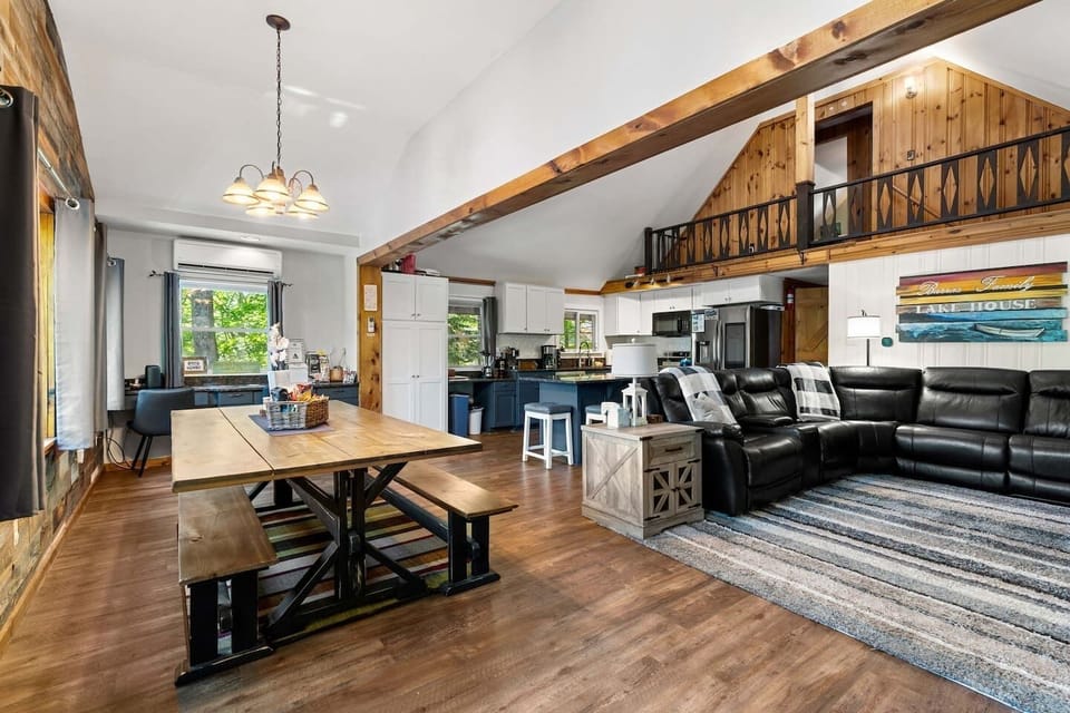 Open concept main living area with fantastic lake views and 70 inch smart TV, desk area and dining for 10+