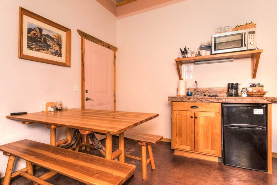 King bedroom dining / workspace table with benches, and kitchenette.