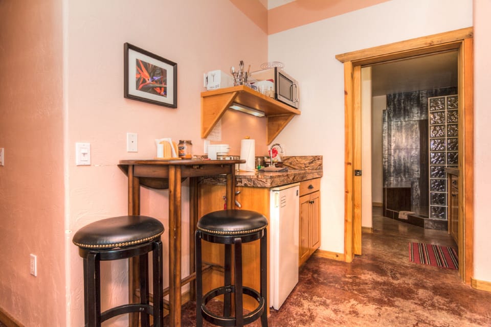 Queen bedroom kitchenette and entrance to private bathroom.