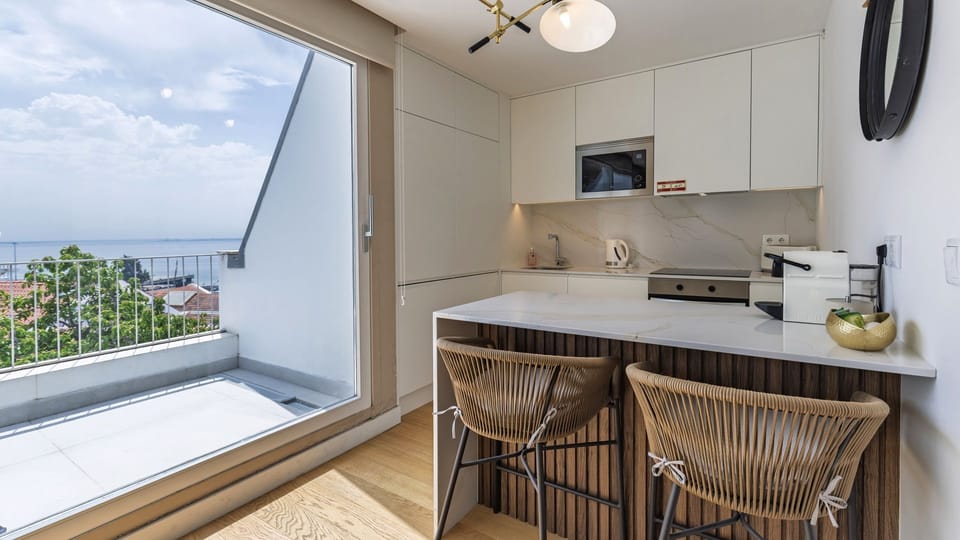 A sleek kitchenette with top-notch appliances and a balcony offering beautiful views.
#PT #Portugal #Lisbon #CityViews #ModernKitchen