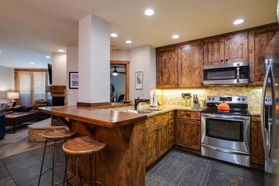 Your gourmet kitchen features rich wood cabinetry, granite counters, and premium stainless appliances perfect for culinary adventures.