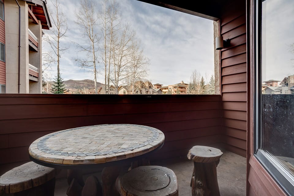 Your private balcony offers peaceful mountain views with rustic stone table seating perfect for morning coffee or evening relaxation.