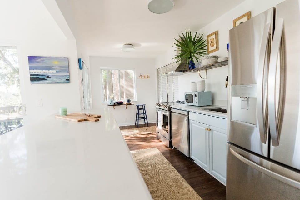 Galley Kitchen with all new appliances, including a refrigerator with a water dispenser. 