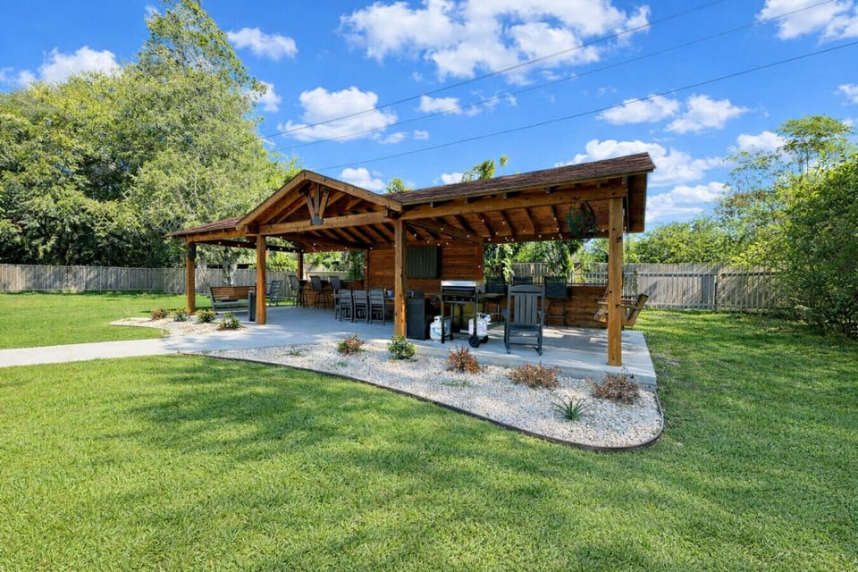 Relax or entertain under the backyard pavilion, equipped with seating, TV, and grill.