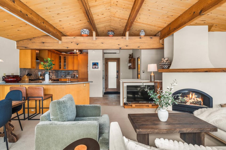 A stunning open-concept mountain retreat featuring exposed wood beams, gourmet kitchen, and sophisticated rustic décor with  natural light throughout.