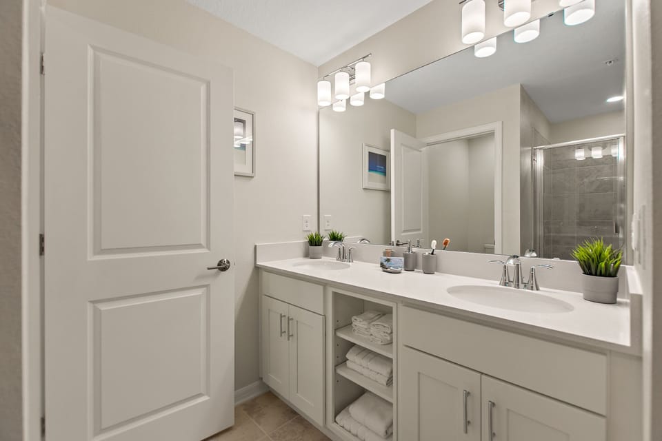 Family bathroom with double vanity and shower over  bath