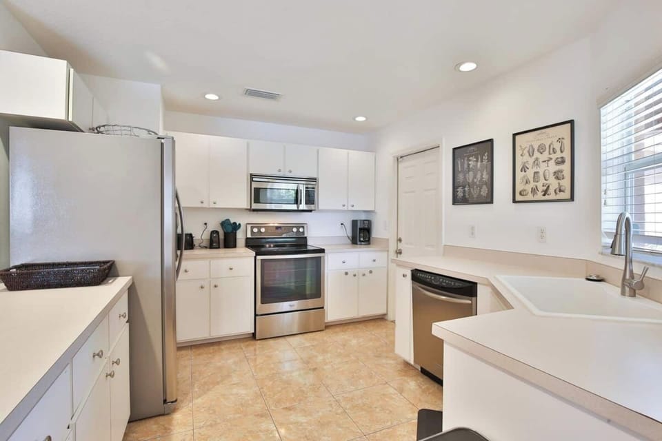 Spacious kitchen with stainless steel appliances and plenty of cooking and baking utensils and tools
