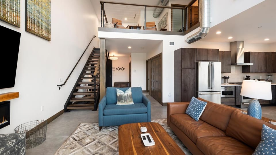 Open concept living room with gas fireplace and SmartTV, dining area, and kitchen with wrap around balcony and hot tub