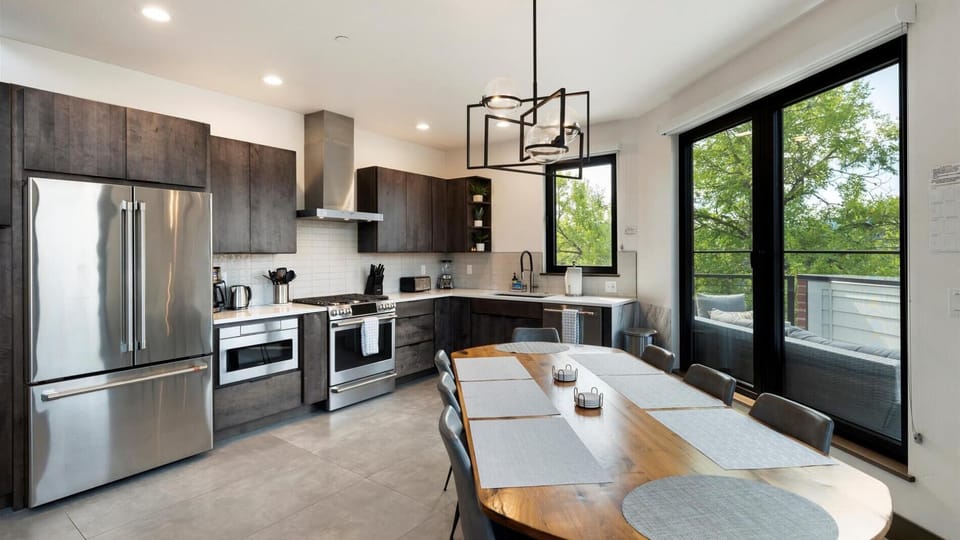 Open concept living room with gas fireplace and SmartTV, dining area, and kitchen with wrap around balcony and hot tub