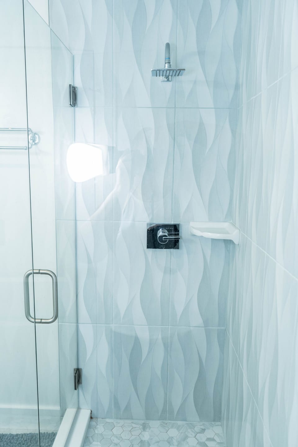 Beautiful bright tile, custom glass and views of the ocean from primary bathroom