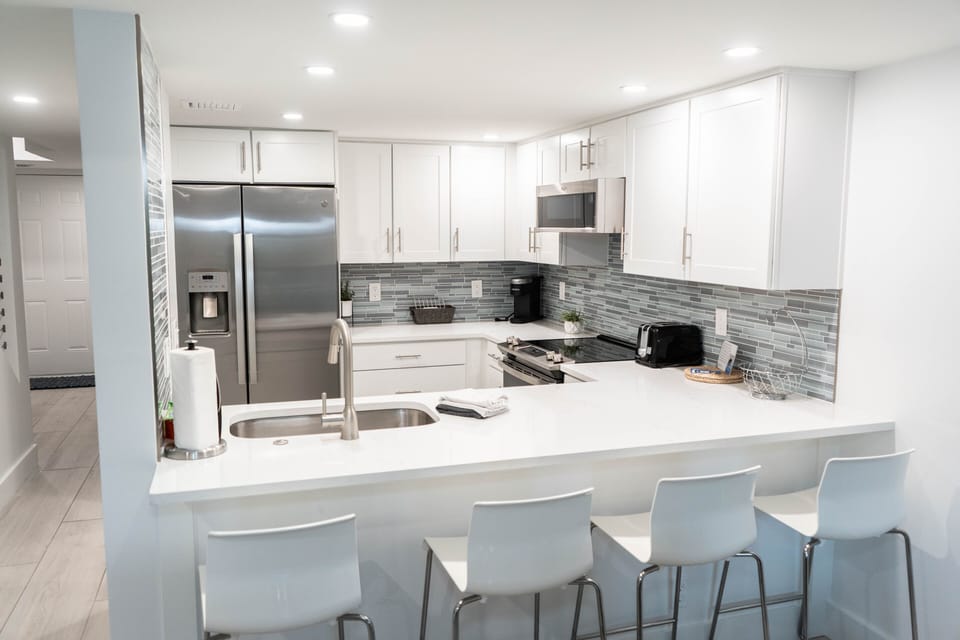 Renovated kitchen w/ quartz & stainless appliances  with barstool seating for 4