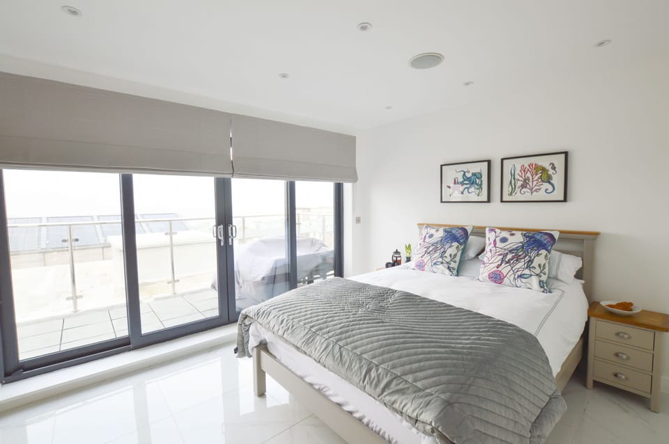 Second floor: Bedroom three with king-size bed and patio doors
