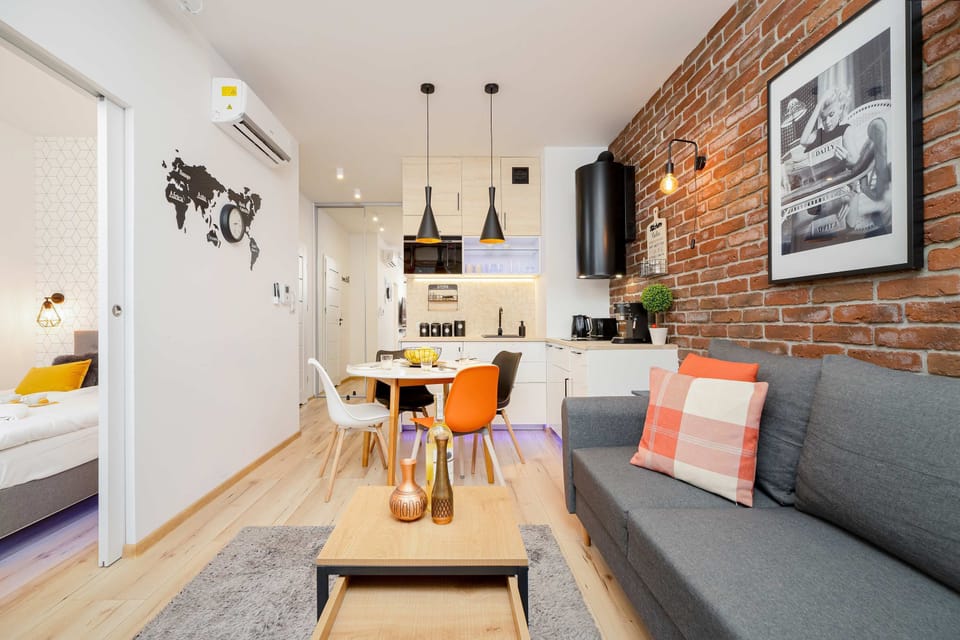 Cozy and air conditioned living room with a double sofa bed, TV and kitchenette.